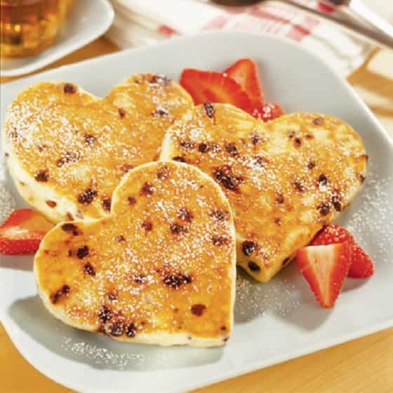 Heavenly Heart Shaped Pancakes are dotted with semi sweet chocolate morsels, and sprinkled with powdered sugar.